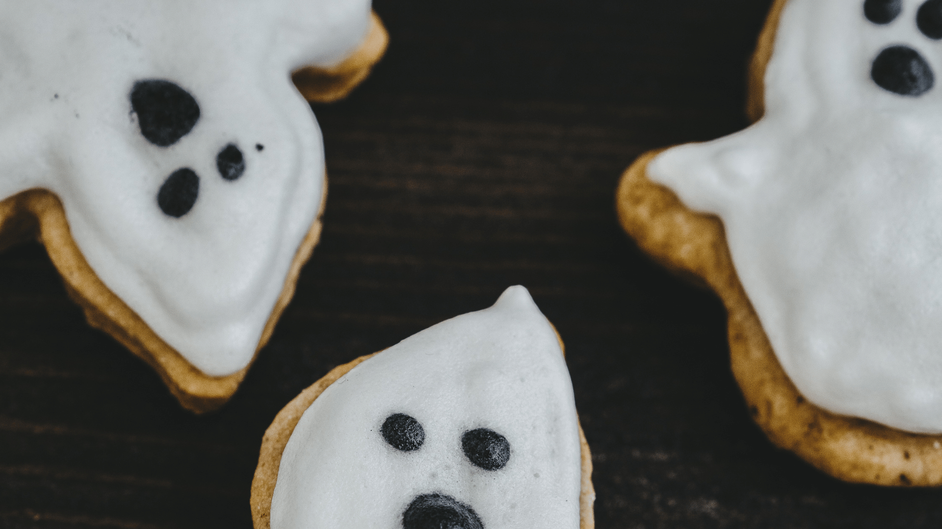 Assorted spooky Halloween snacks like mummy hot dogs, ghost cookies, and caramel apples with Mealmento