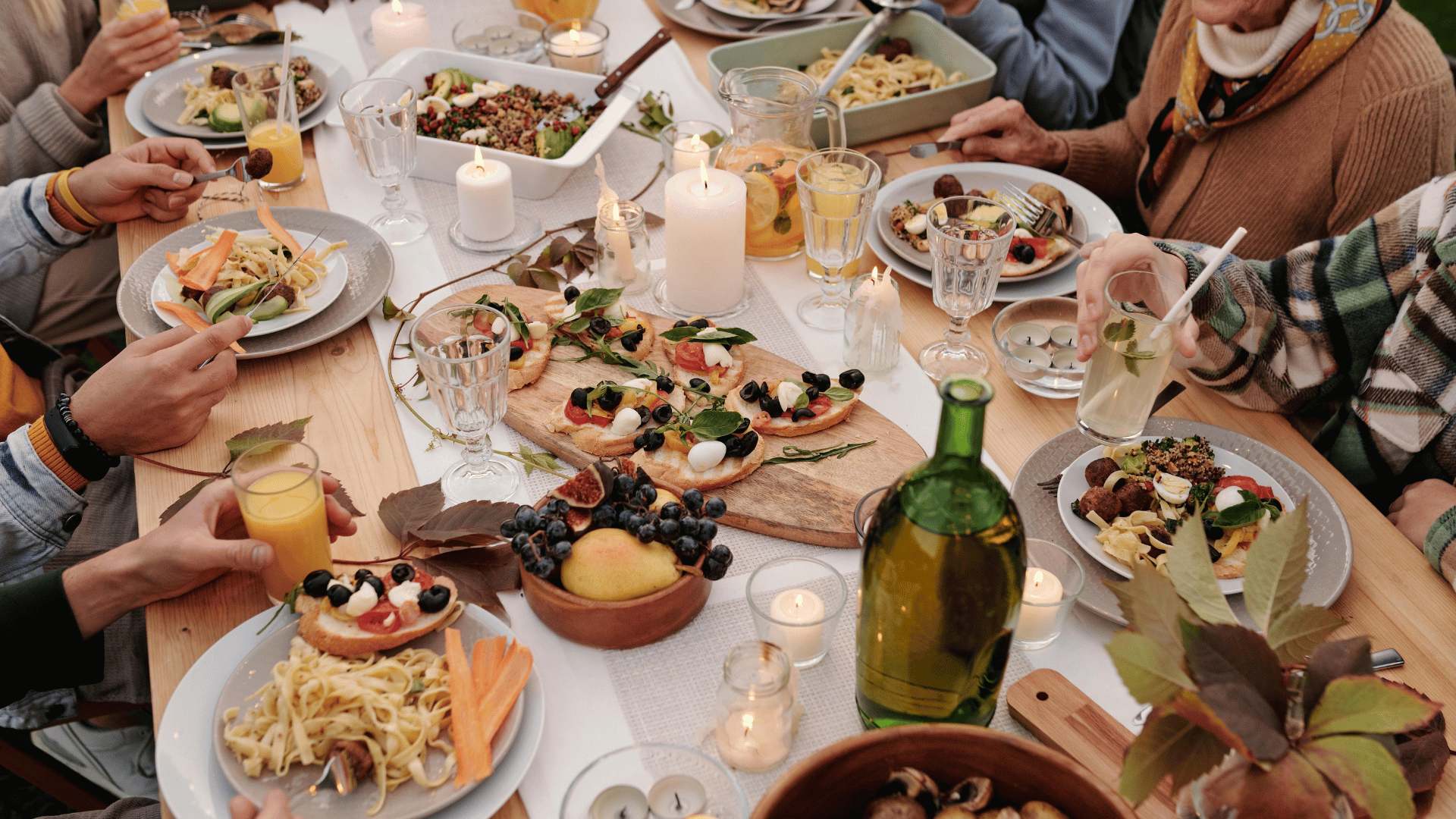 Family gathered around a kitchen table sharing recipes and stories with Mealmento